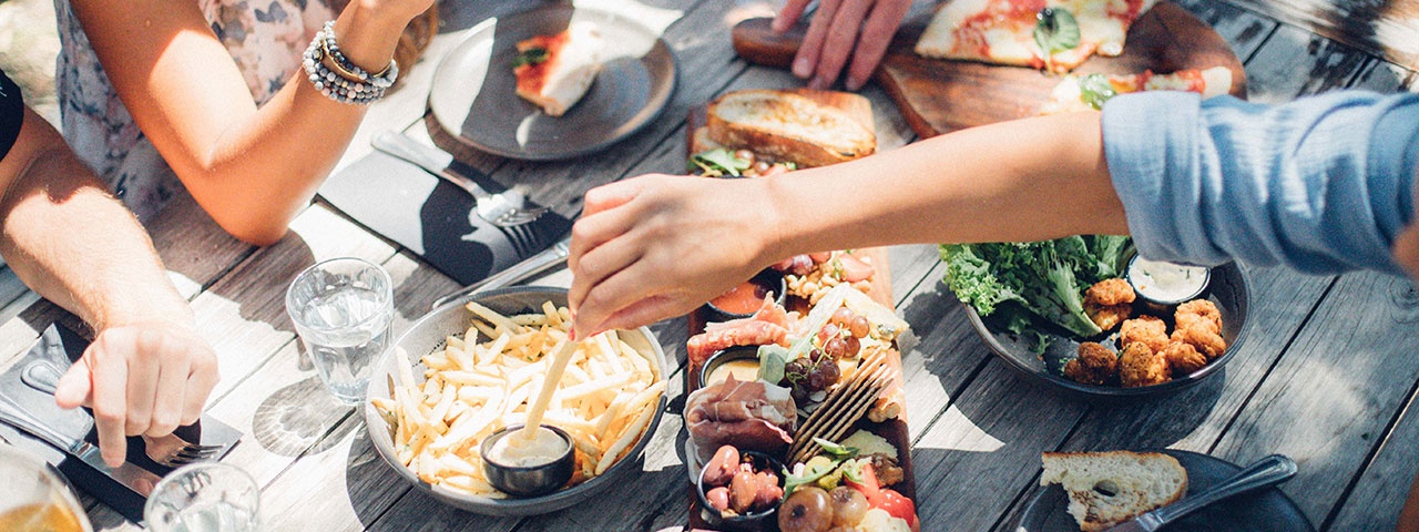 Birds eye view of friends eating platters al fresco at a casual eatery on Waiheke Island