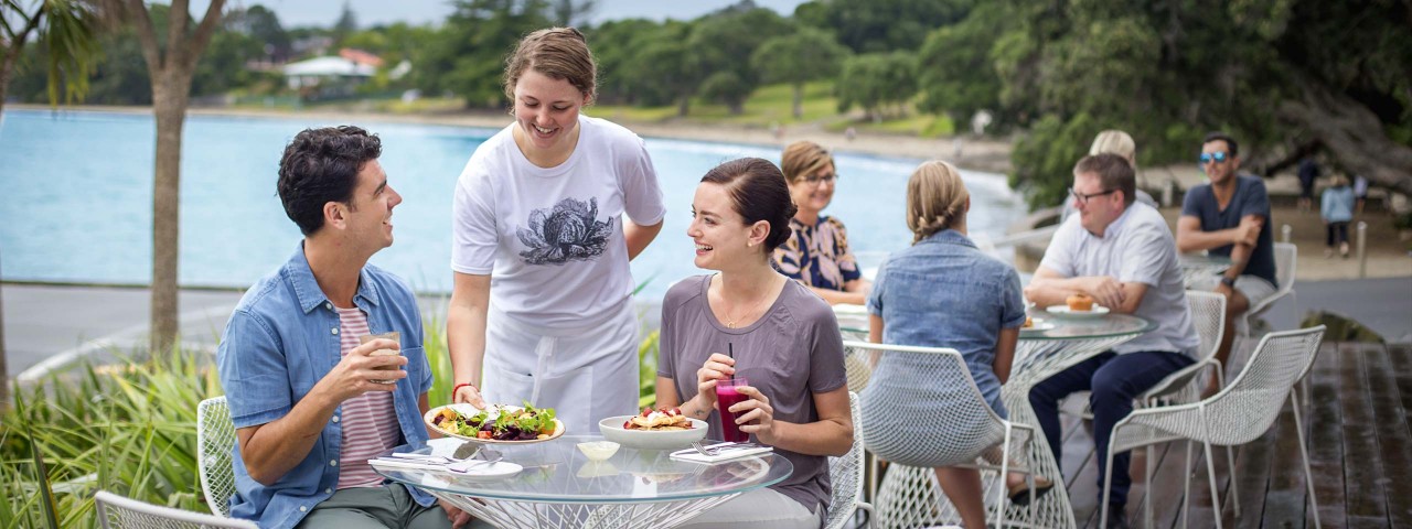 Couple being served at outdoor table at a cafe (credit: ATEED / Milles Holden)