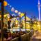 People drinking outdoors at restaurant under coloured lights with Sky Tower in the background (credit: Todd Eyre) 