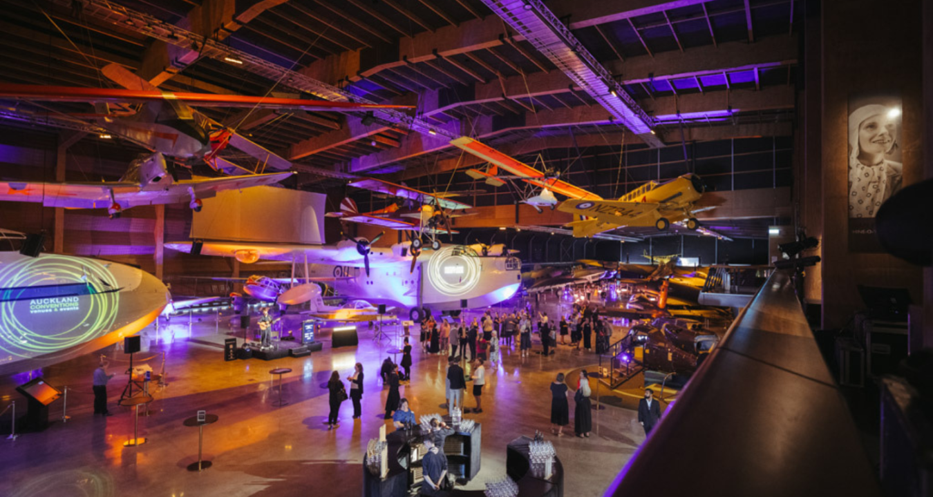 The MOTAT Aviation hall set up for an event with a bar setup in the forefront and lots of guests