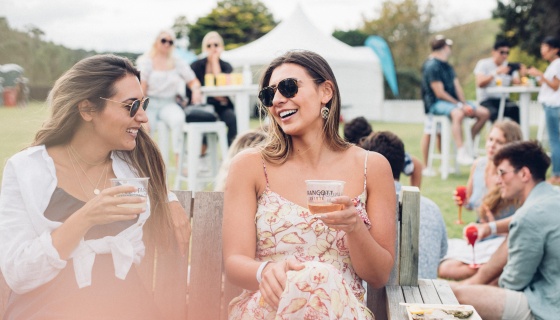 Two women enjoying a drink and oysters