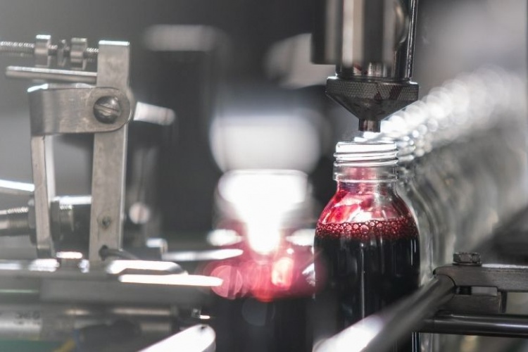 Bottle being filled on conveyor belt