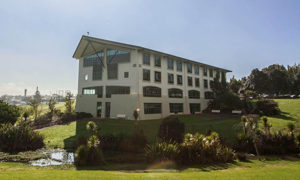 Large building surrounded by grass and trees